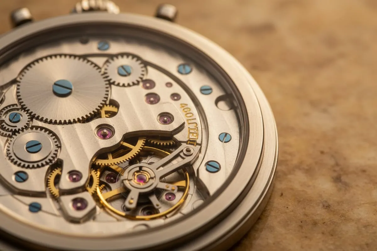 The exposed movement of a mechanical pocket watch, gears and springs in close focus